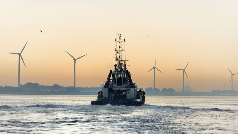 schiff auf dem wasser im Hintergrund landschaft mit windkrafträdern