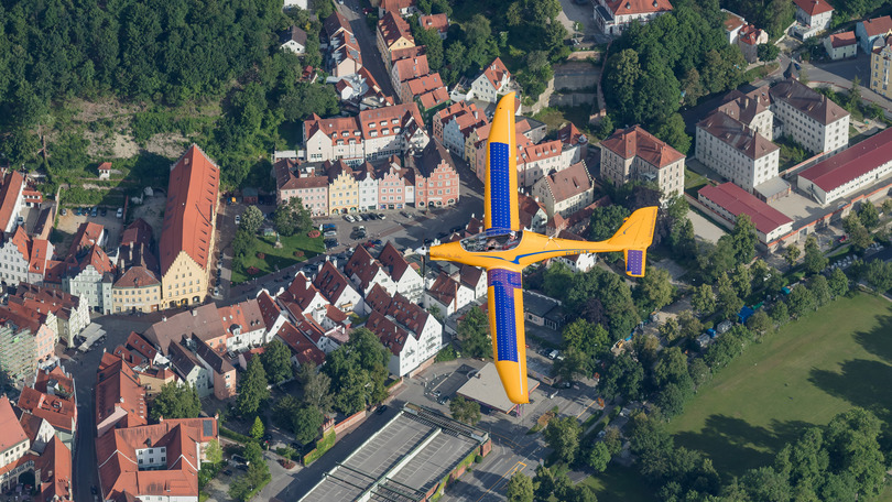 Luftbildaufnahme von einer stadt und im vordergrund segelflugzeug