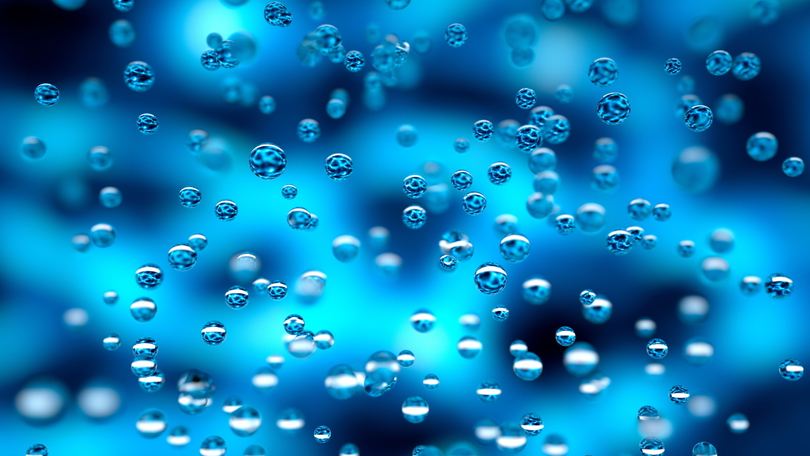 Schwebende Wassertropfen vor einem blauen Hintergrund mit Helligkeitsverlauf