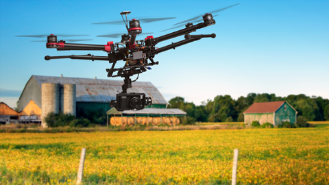 Drohne über ein Feld an einem Bauernhof