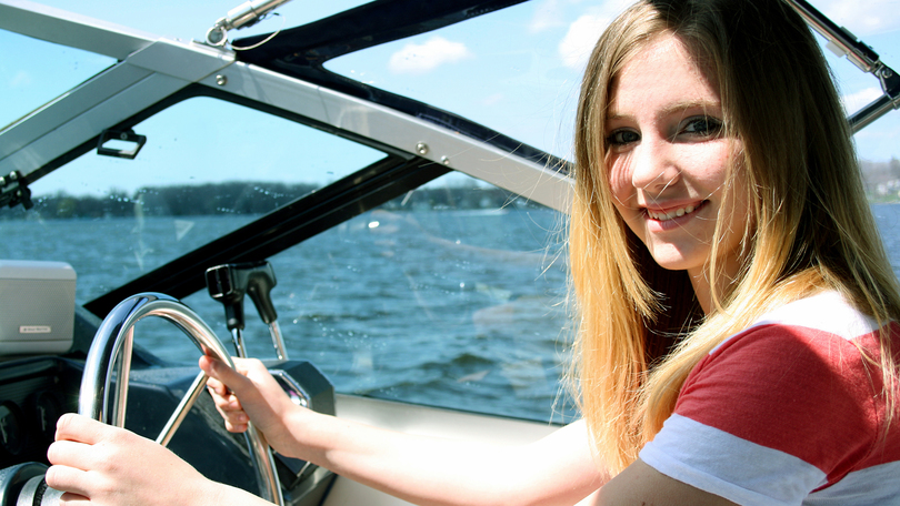 Mädchen am Steuer vom Boot